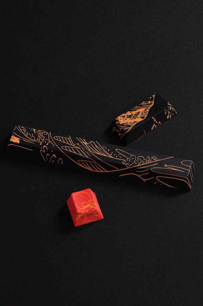 testimonials-img Artistic shot of black and red keyboard keycaps, showcasing intricate designs on a dark background.